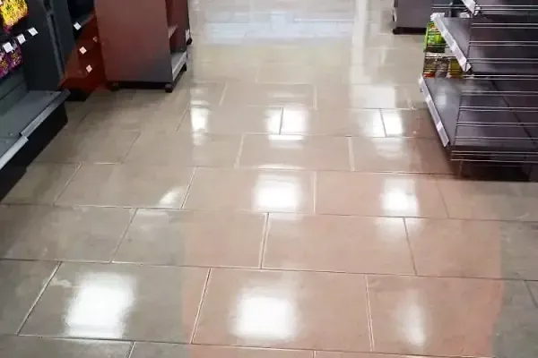 Glossy tile floor in a store aisle reflecting the overhead lights