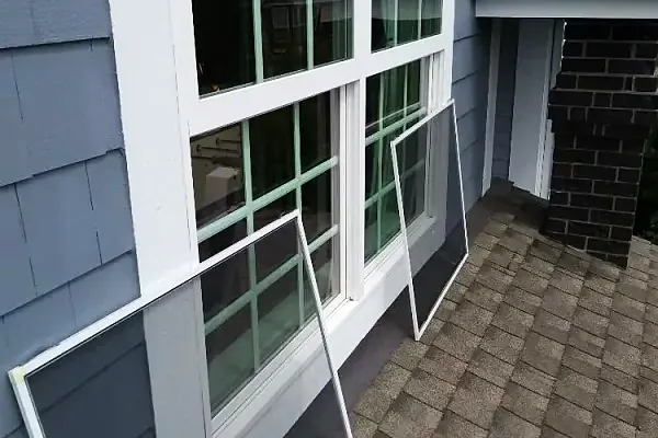 Window screens removed and set against the siding while the glass and frames are cleaned